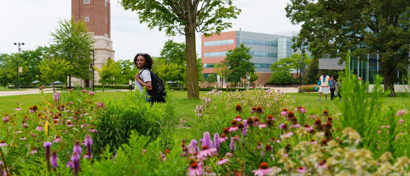 An Oakland University student walking on campus.